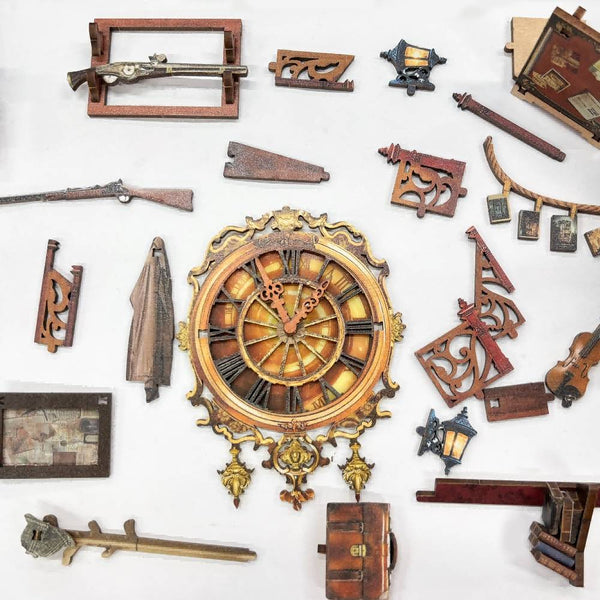 miniatures of the Bell's Mystery DIY Book Nook are displayed on table, including clock, rifle, coat, briefcase, lamp. and so on