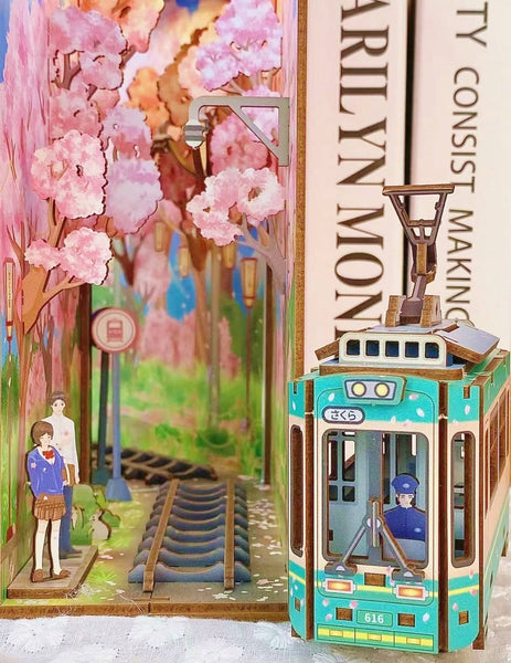 Japanese Sakura Densya DIY Book Nook Kit, A charming miniature 3d wooden puzzles the captures the essence of springtime in Japan, perfect for bookshelf decor or a delightful gift for Japanese culture lovers. Scene 1